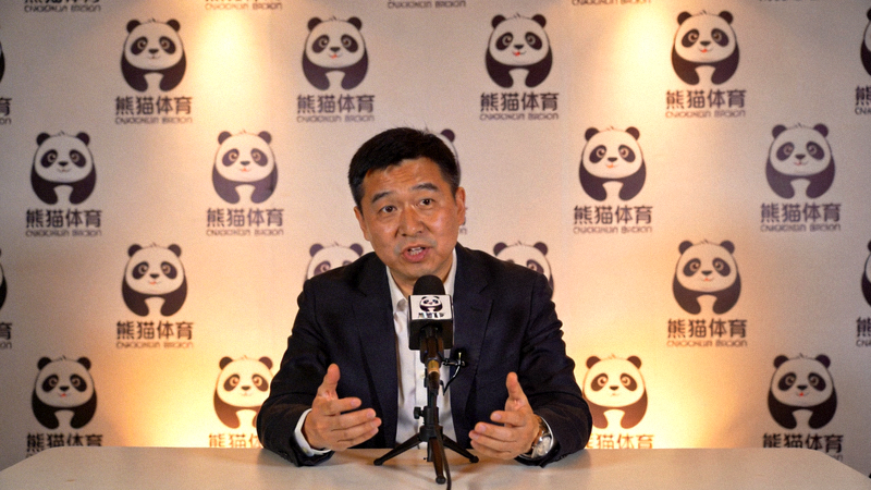 熊猫体育负责人专访现场照片 - 负责人正在接受采访，背景是熊猫体育的Logo墙